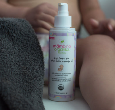 Our Nurture Me Massage Oil in between a baby's legs